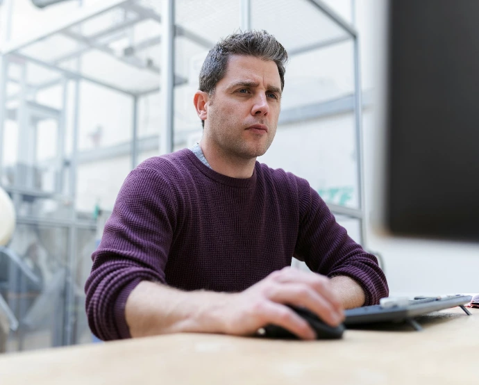 man in purple sweater sitting at the table